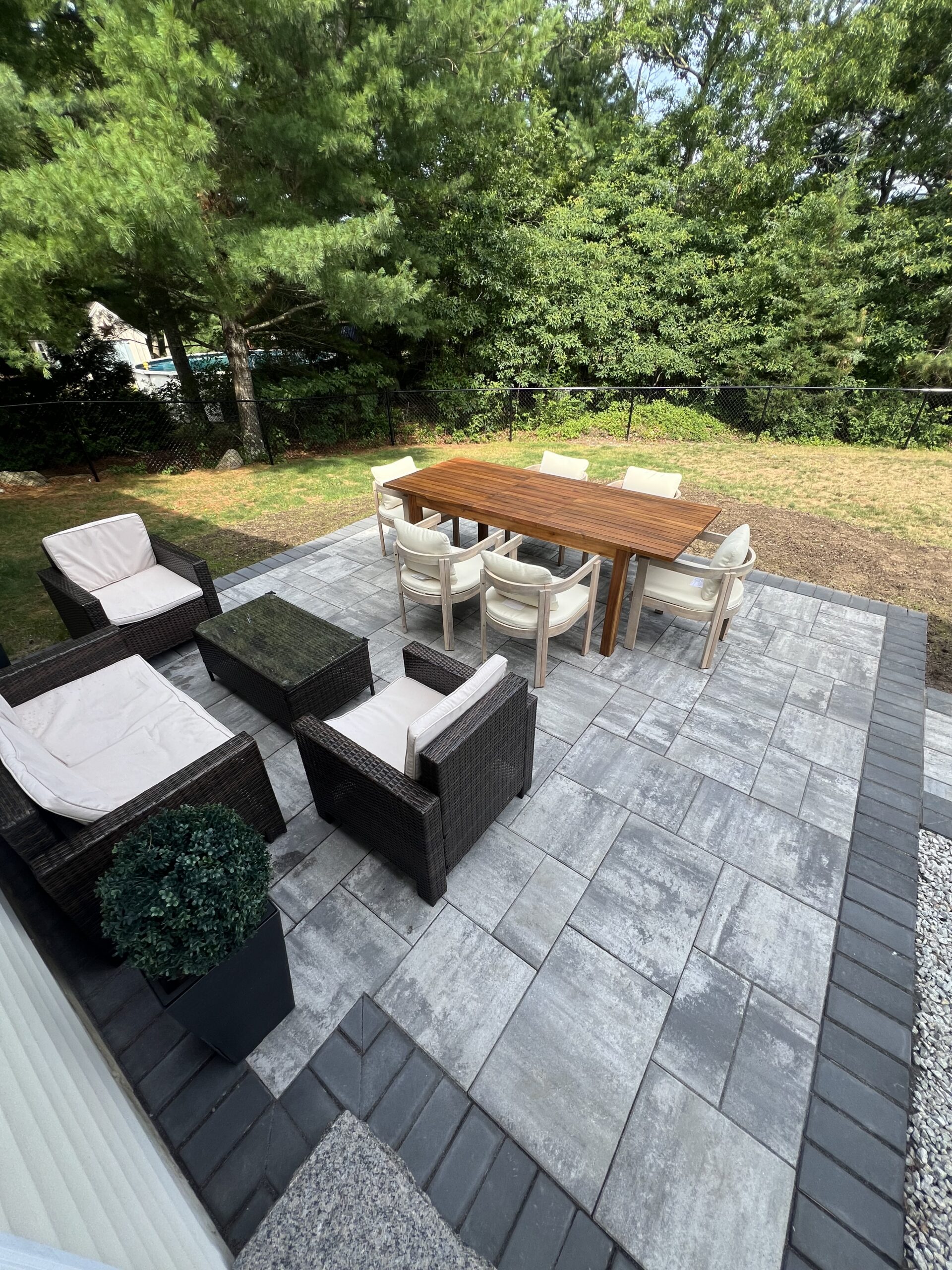Finished paver patio with outdoor dining and lounge furniture